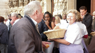 Une boulangère distribue le pain béni par Mgr Jérôme Beau.
