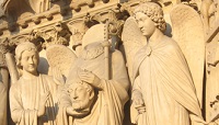Portail de la Cathédrale de Paris. Saint Denis portant sa tête entouré de deux anges.